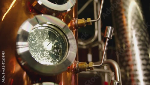 Hot water , liquid boiling inside distillery or filtration tank . Alcohol drink factory or physical experiment laboratory . Cooper or metal machine . Hot temperature , high pressure . Close up