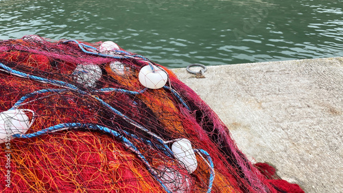 Detail of some red fishing nets deposited in a port 