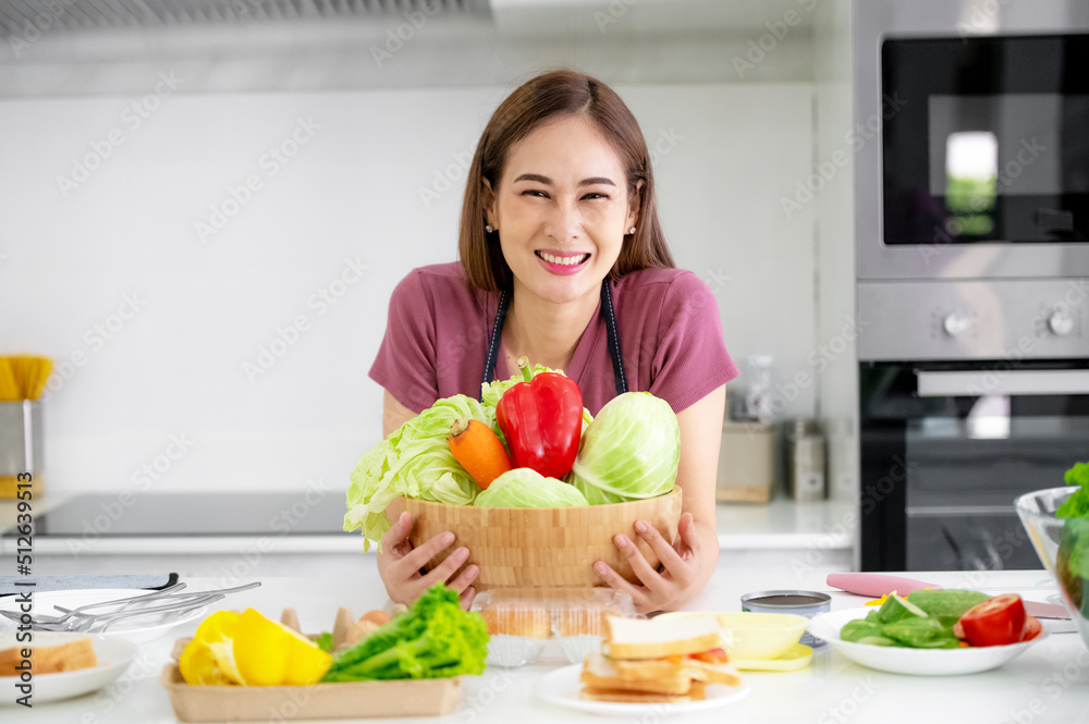 Asian women smiling in kitchen cooking salad vegetable eat healthy