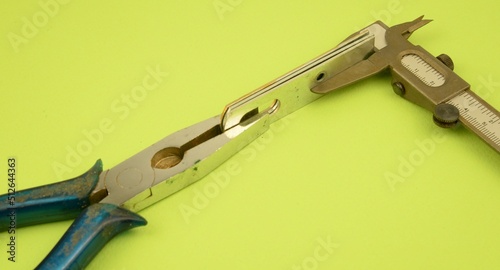 Attrezzi e materiali per il laro manuale: pinza, staffa e calibro in metallo photo