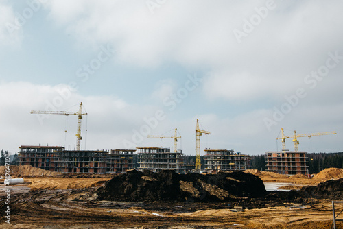 cranes on the background of construction site of houses in Scandinavian style