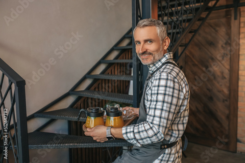 Man with tray going up stairs turning to camera