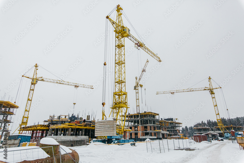 cranes on the background of construction site of houses in Scandinavian style