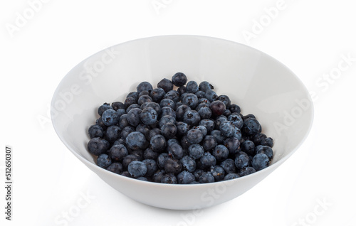 Washed large ripe blueberries in a white bowl. isolated on white background.