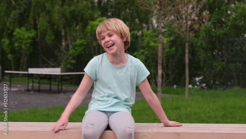 The child sits on a trap and laughs. A teenage girl is very funny