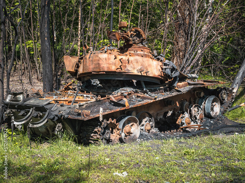 The war in Ukraine, a destroyed tank with a torn tower stands in a forest near the road, Severodonetsk. photo