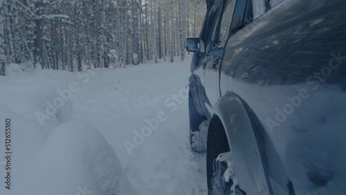 Jeep rides on the snow in the forest closeup.