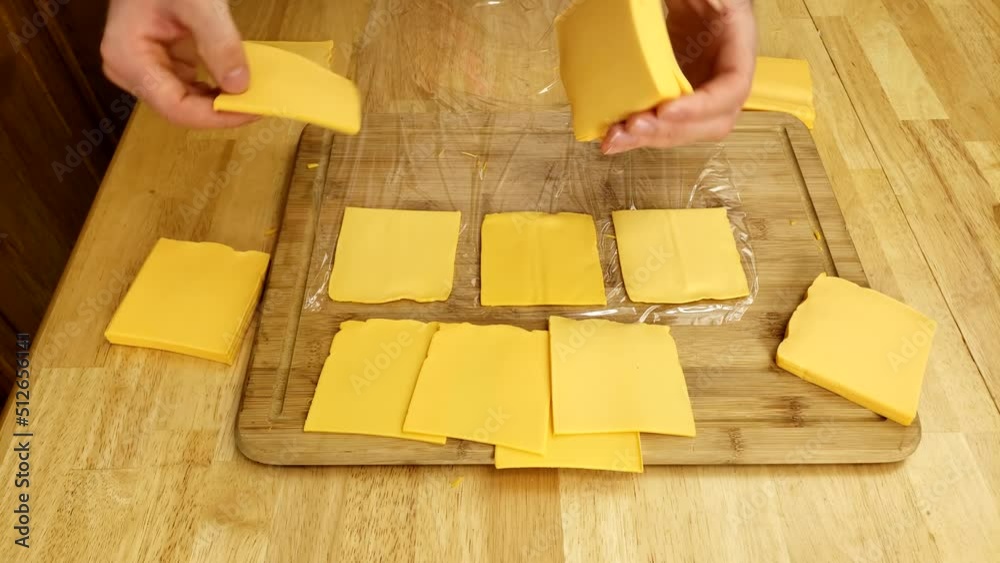 Splitting chunks of cheese singles into individual slices for repacking into smaller packages. Splitting chunks of cheese singles into individual slices for repacking into smaller packages.