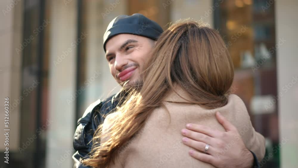 Hypocritical gay man hugging friend rolling eyes smiling. Portrait of insincere young Caucasian LGBTQ person meeting woman outdoors on city street embracing. Hypocrisy and dissimulation concept