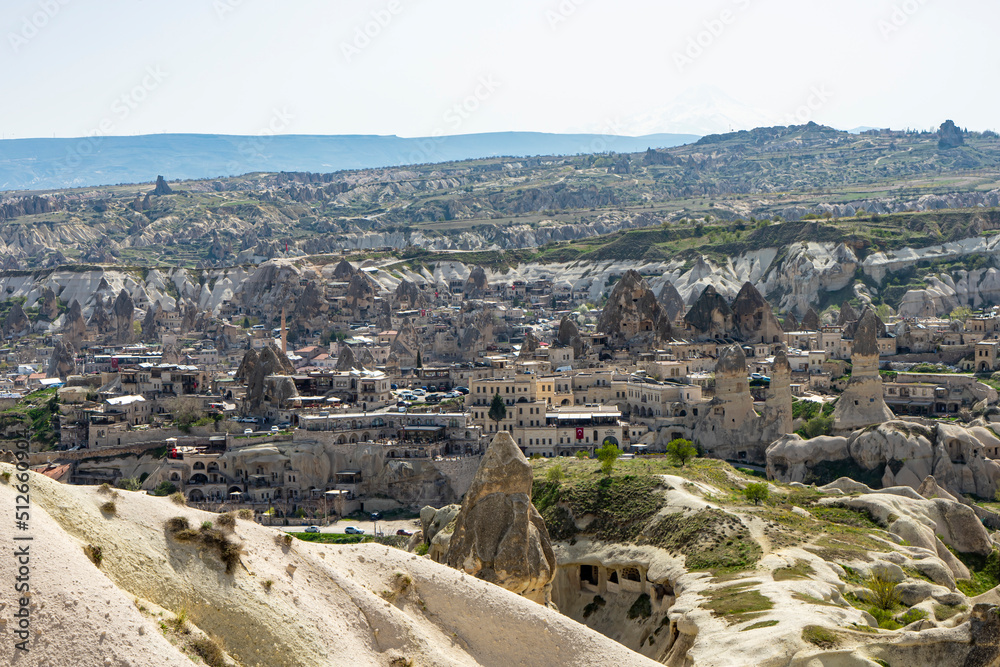 Goreme town with fairy chimneys and mountains on the background in Cappadocia, Central Anatolia, Turkey. 