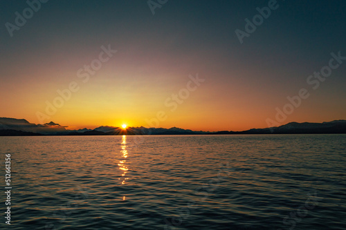 atardecer en el lago, detrás de las montañas