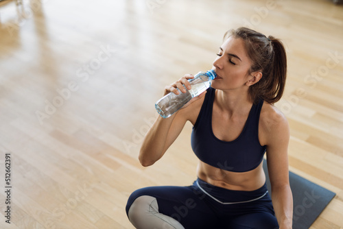 Young woman drinking fresh water after sports training