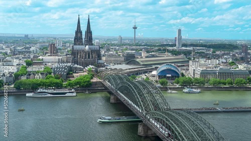 Time lapse shot of Cologne skyline and Cathedral with the Muscical Dome and the Hohenzollern Bridge on a summer day in Cologne, Germany photo