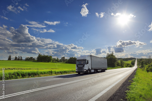 Landscape with a moving truck on the highway at sunset