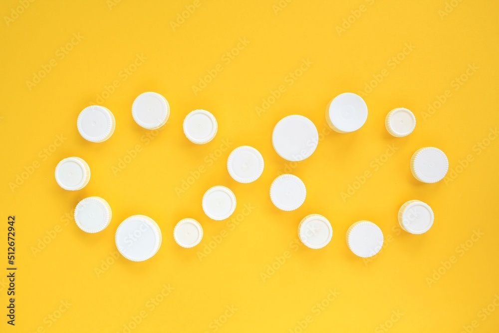 Sign of infinity from white plastic bottle caps on yellow background. Reuse of waste, reduce recycle idea. World Environment Day, Earth Day concept. Cycle of circulation. Save the planet, flatlay Sign of infinity from white plastic bottle caps on yellow background. Reuse of waste, reduce recycle idea. World Environment Day, Earth Day concept. Cycle of circulation. Save the planet, flatlay