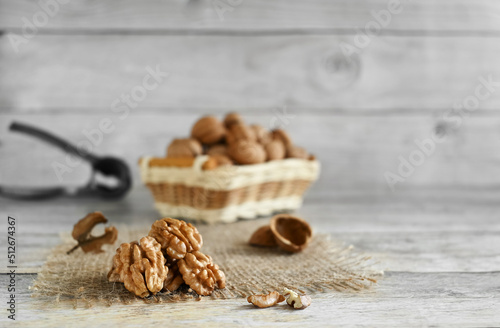 Walnuts are split on a wooden table, copy space. They contain B vitamins, vitamin C, vitamin PP, vitamin A, vitamin E; minerals sodium, potassium, iron, magnesium, iodine, zinc, cobalt, phosphorus