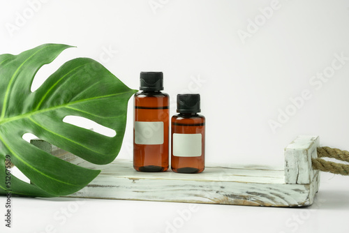 CBD hair natural oil or serum standing on the white wooden tray