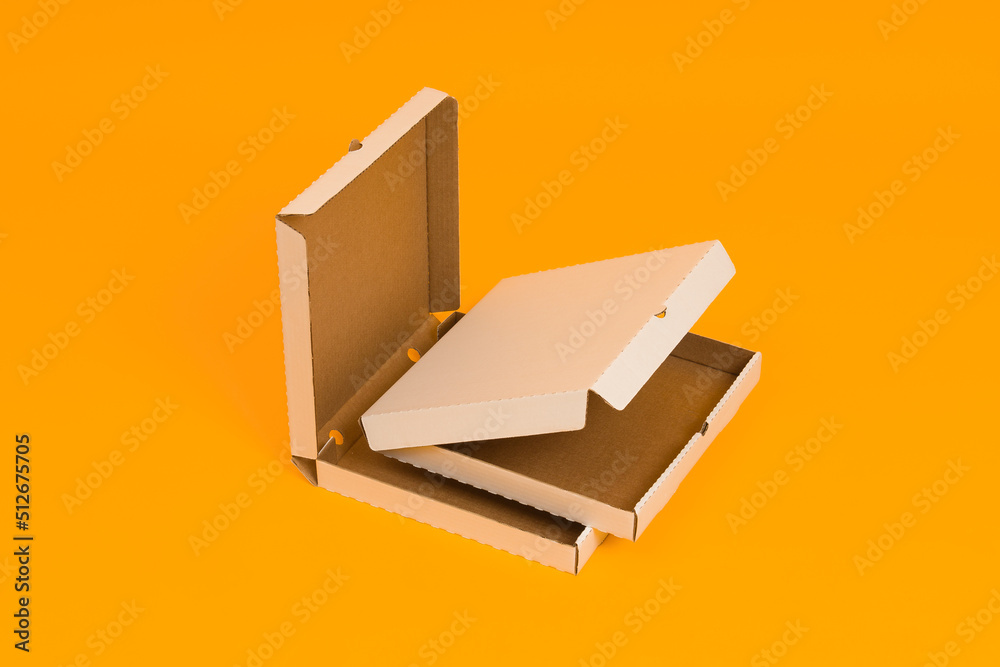 two pizza boxes open on yellow background two pizza boxes open on yellow background