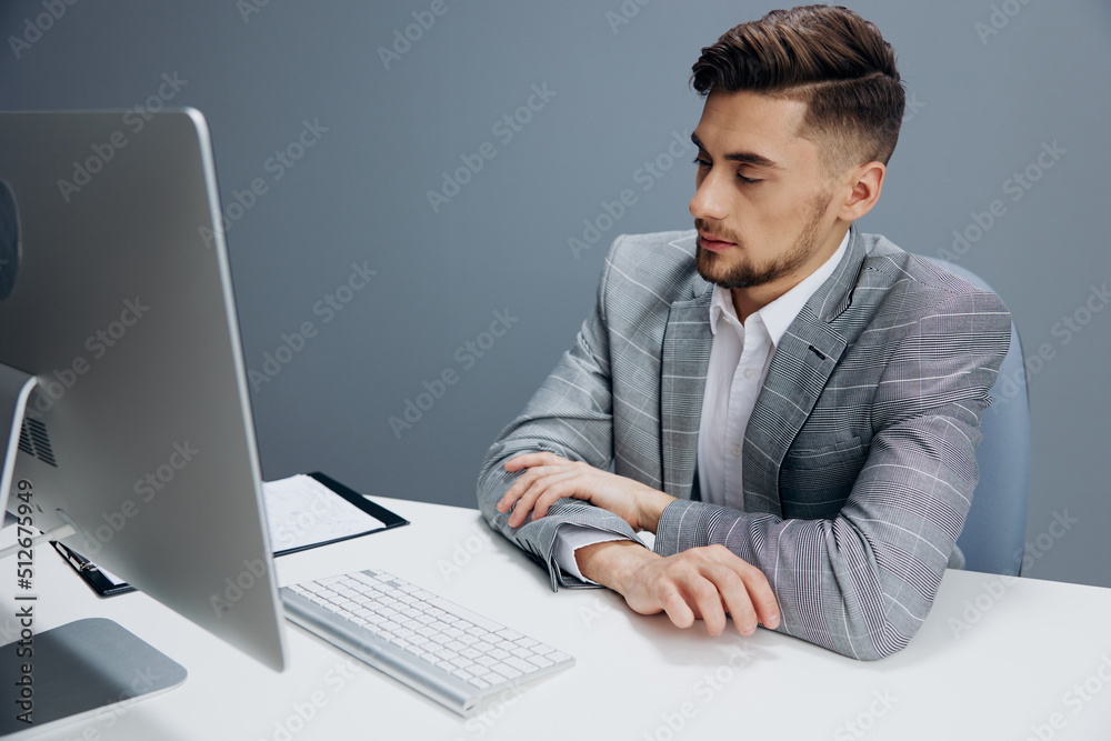 businessmen in a gray suit sits in front of a computer executive businessmen in a gray suit sits in front of a computer executive
