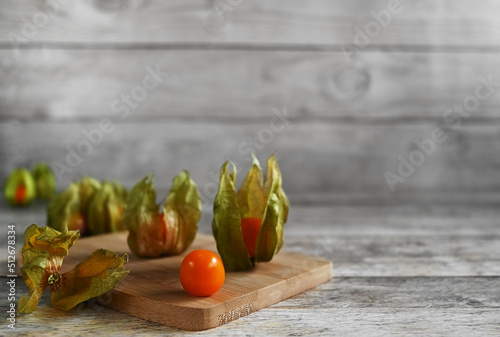 Ripe healthy physalis, over wooden board on a wooden background, copy space