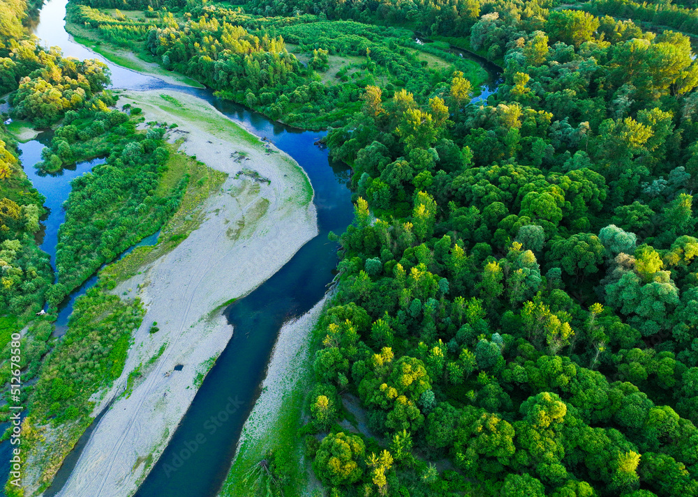 A rocky river in the middle of a forest. Aerial view of tranquil river reflecting sky, amid lush green landscape, aerial view. Top view of a mountain river in the forest. A rocky river in the middle of a forest. Aerial view of tranquil river reflecting sky, amid lush green landscape, aerial view. Top view of a mountain river in the forest.