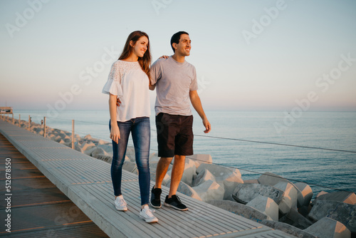 A Hispanic man and his girlfriend are strolling on a breakwater in Spain © Roman Tyukin