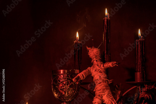 Voodoo Doll on a wooden background with dramatic lighting. photo