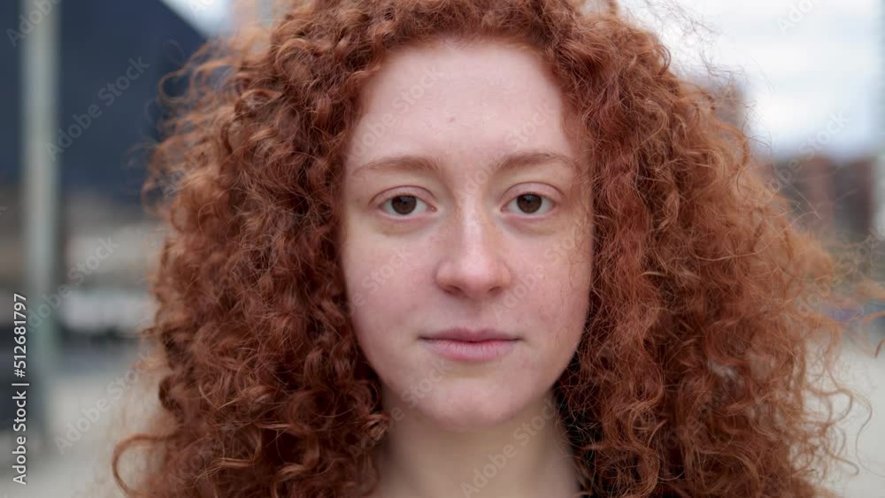 Young ginger woman looking at camera outdoor Young ginger woman looking at camera outdoor