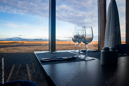 Close-up of wine in glasses on table. Alcoholic beverages are served against window with view of cloudy sky. Concept of catering in restaurant at luxurious resort. © Aerial Film Studio