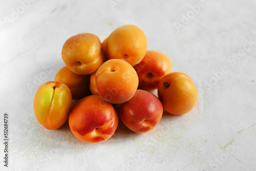 Heap of fresh ripe apricots on a table made of natural marble, copy space. Apricots are rich in vitamins and minerals such as: vitamin A, beta-carotene, vitamin C, potassium, silicon, cobalt