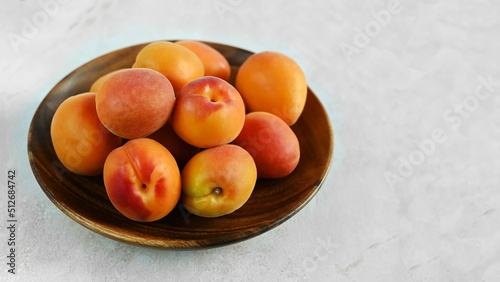Bowl of fresh ripe apricots  on a wooden table, copy space