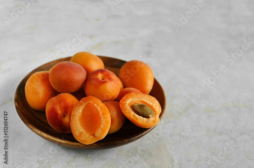 Bowl of fresh ripe apricots on a natural marble table, copy space. Apricots are rich in vitamins and minerals such as: vitamin A, beta-carotene, vitamin C, potassium, silicon, cobalt, manganese
