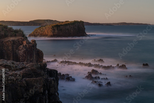 Rock cliff and big island view with clear sky.