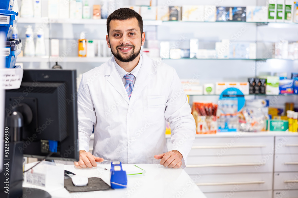 Portrait of male pharmacist working at the cash register in a pharmacy