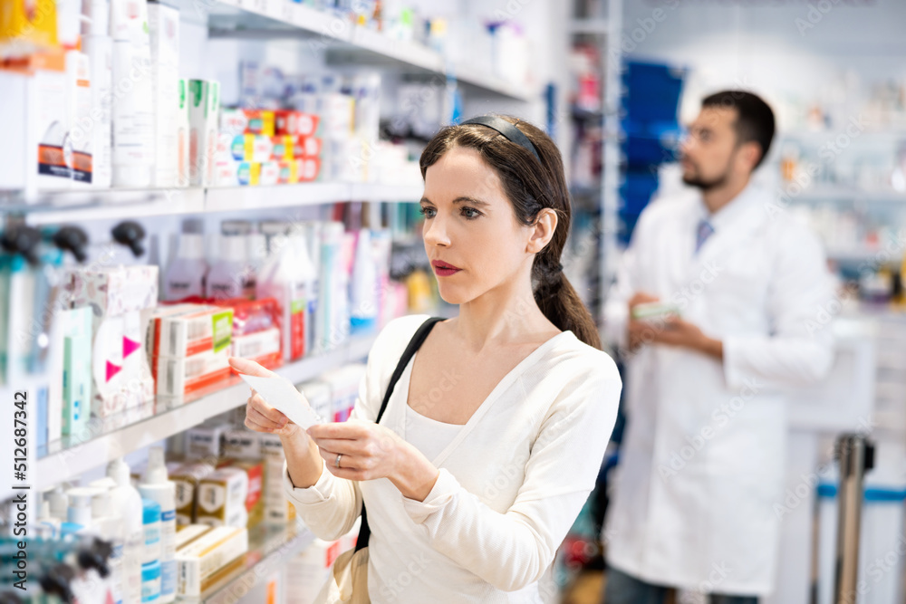 Woman with drug order shopping in drugstore. Female client in pharmacy.