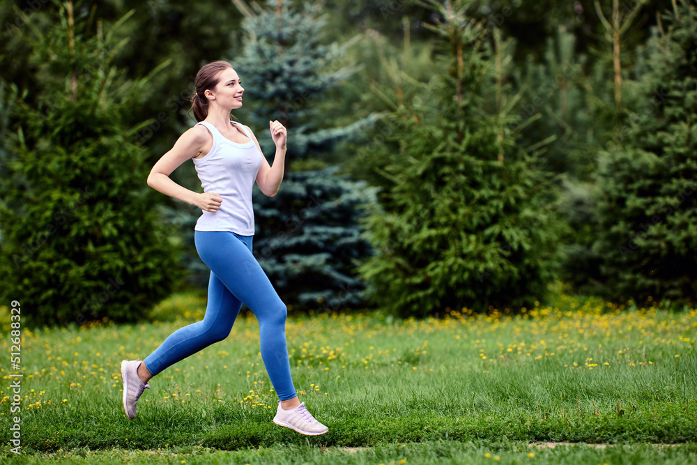 Jogging in forested area, young runner woman trains in nature.