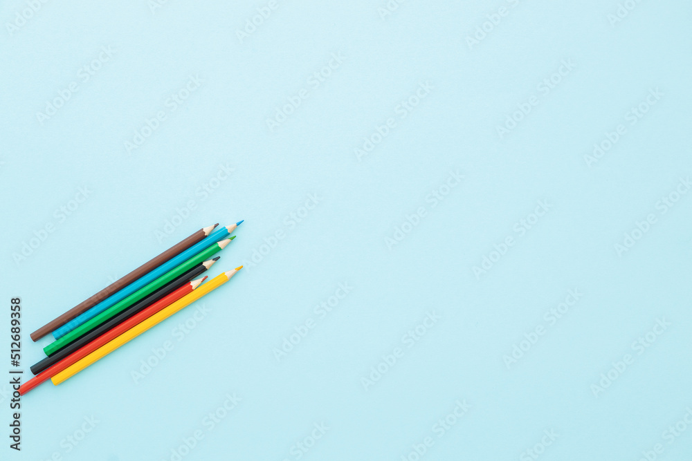 colored pencils row with wave on blue background