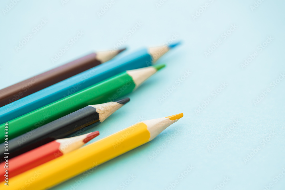 colored pencils row with wave on blue background