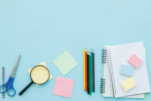 Flat lay composition with school supplies on blue background, space for text
