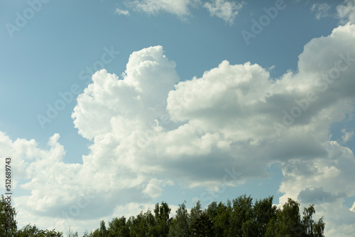 White clouds in sky. Summer landscape. Forest and clouds.
