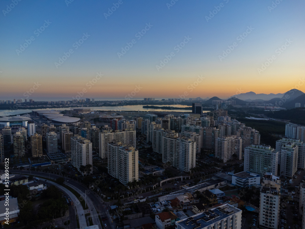Aerial view of Jacarépagua lagoon in Rio de Janeiro, Brazil. Residential buildings and mountains around the lake. Barra da Tijuca beach in the background. Sunny day. Sunset. Drone photo