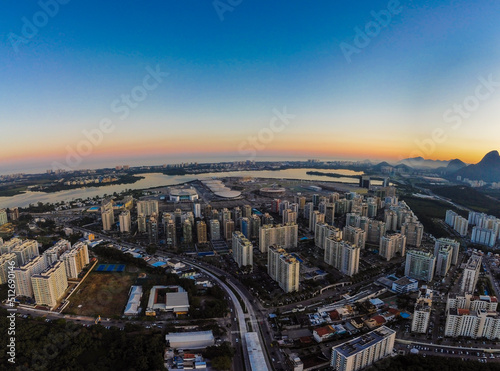 Aerial view of Jacarépagua lagoon in Rio de Janeiro, Brazil. Residential buildings and mountains around the lake. Barra da Tijuca beach in the background. Sunny day. Sunset. Drone photo photo