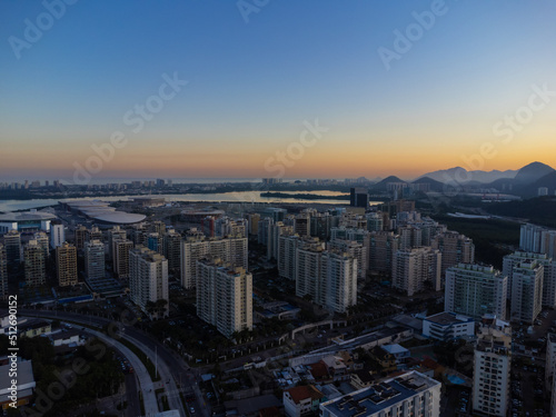 Aerial view of Jacarépagua lagoon in Rio de Janeiro, Brazil. Residential buildings and mountains around the lake. Barra da Tijuca beach in the background. Sunny day. Sunset. Drone photo