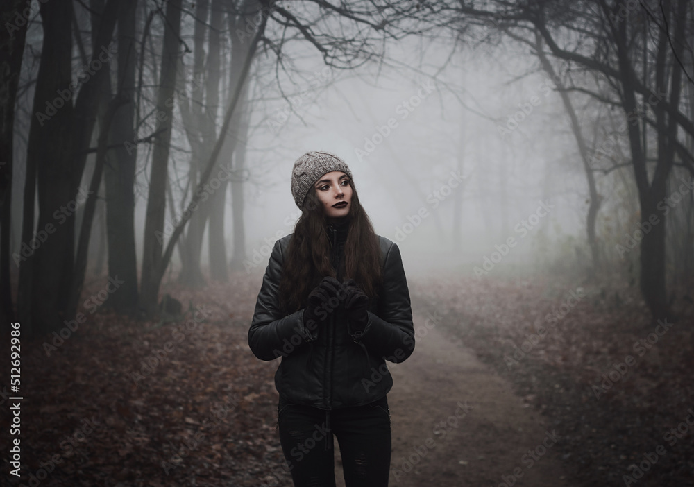 Gothic witch. Ghost in the fog. Girl in the paranormal world. Stranger forest in a fog. Mystical atmosphere. Dark wood. Mysterious road. Background wallpaper. Gloomy times. Dark background