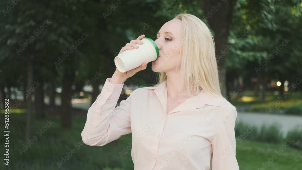 Beautiful business woman in a shirt, black skirt drinks coffee from a disposable cup, standing in the park. Hot drink glass
Beautiful business woman in a shirt, black skirt drinks coffee from a disposable cup, standing in the park. Hot drink glass