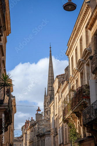 Facade of medieval buildings in a dark street, narrow, in the city center of Bordeaux, France in front of catholic basilique saint michel basilica. These buildings are typical of Southwestern France