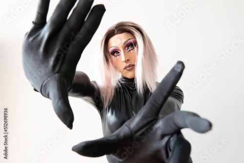 lgbtiq drag queen posing for the camera in a black latex and leather outfit looking to the side. High quality photo