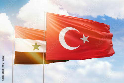 Sunny blue sky and flags of turkey and syria photo