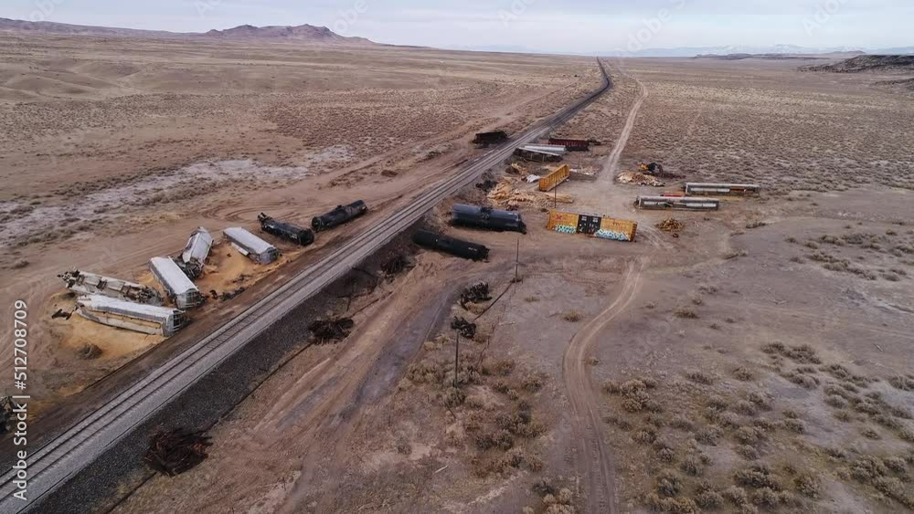 Carnage from a train wreck with debris and cars on both sides of the tracks in the Utah desert during clean up.