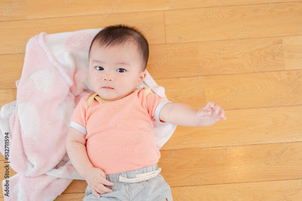 おうちの床に寝転がる赤ちゃん おうちの床に寝転がる赤ちゃん